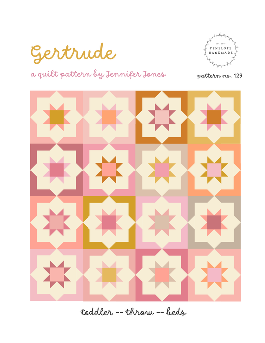 Quilt pattern cover with geometric star design in pink, orange, and beige on a white background.