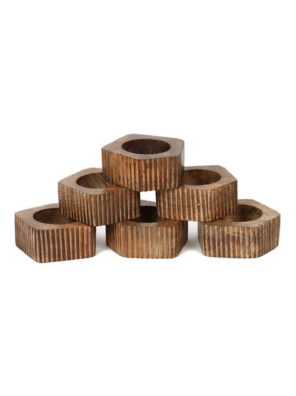 A stack of wooden napkin rings with textured surface on a white background