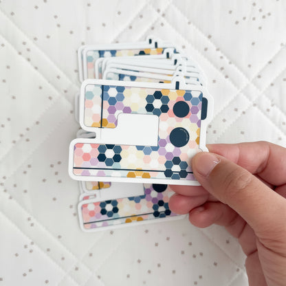 Hand holding a card with a colorful geometric pattern on a white textured background