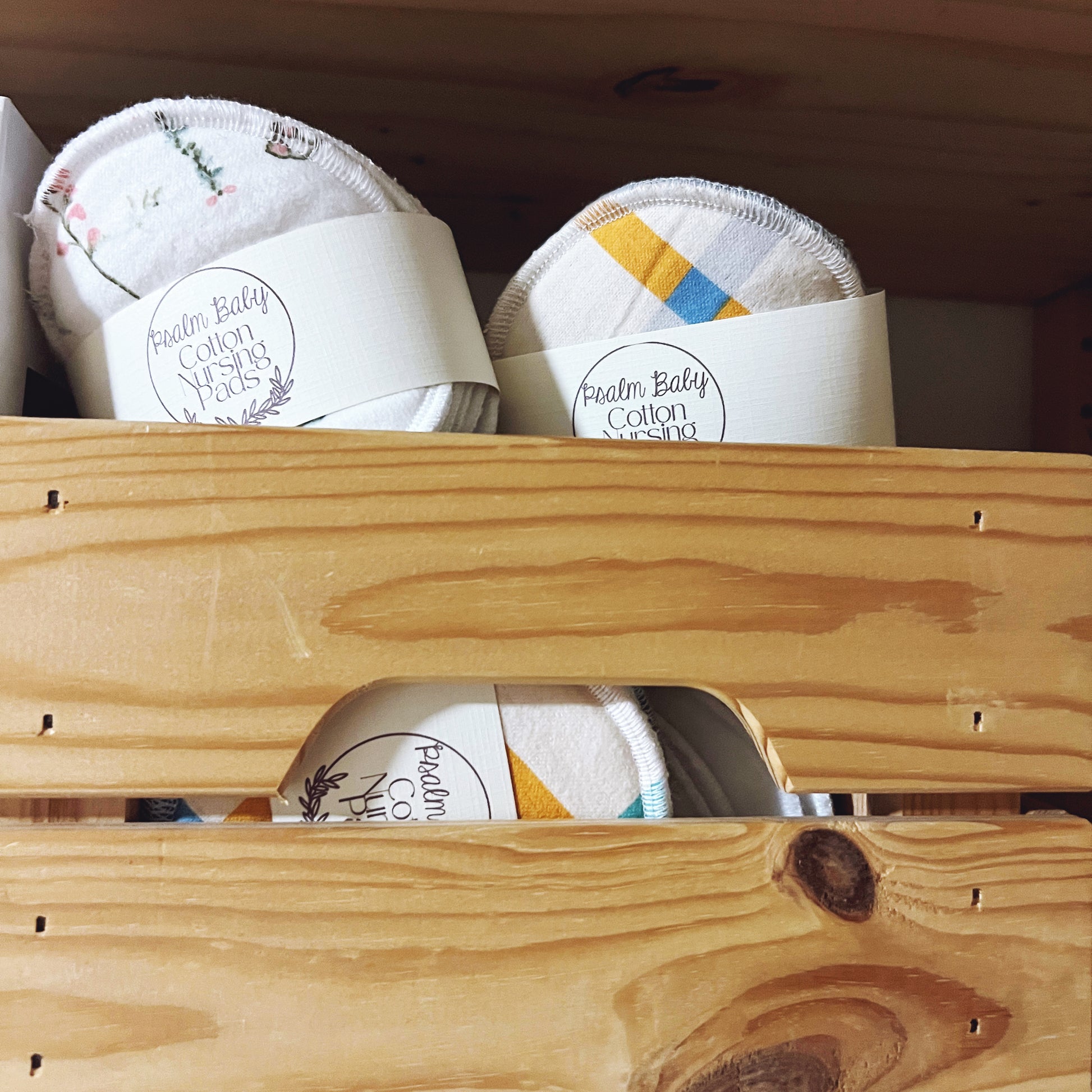 Cotton pads in a wooden holder with Psalm Baby Cotton branding.
