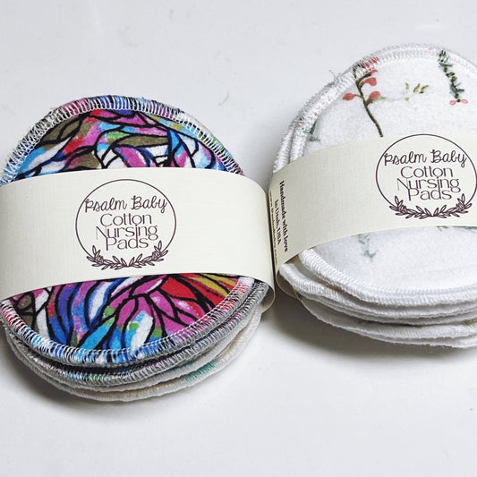Cotton nursing pads with colorful and white designs on a white background, branded 'Psalm Baby'.
