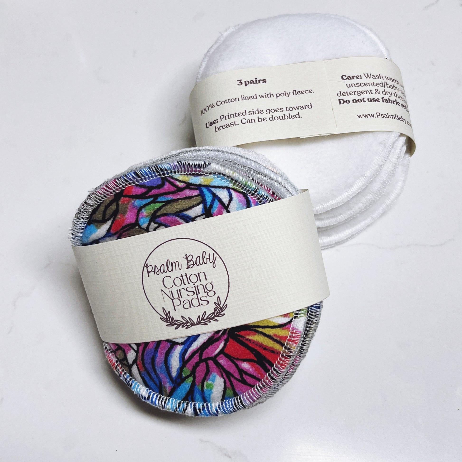Cotton nursing pads with colorful design in packaging on a white background