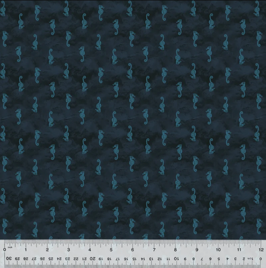 Dark navy blue fabric with a repeating pattern of small teal seahorses, shown flat with a white ruler along the bottom edge for scale.