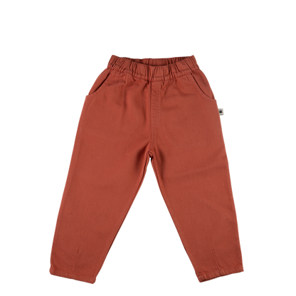 A pair of toddler's wide-leg pants in a terracotta rust color, featuring an elastic waistband and side pockets, laid flat on a white background.